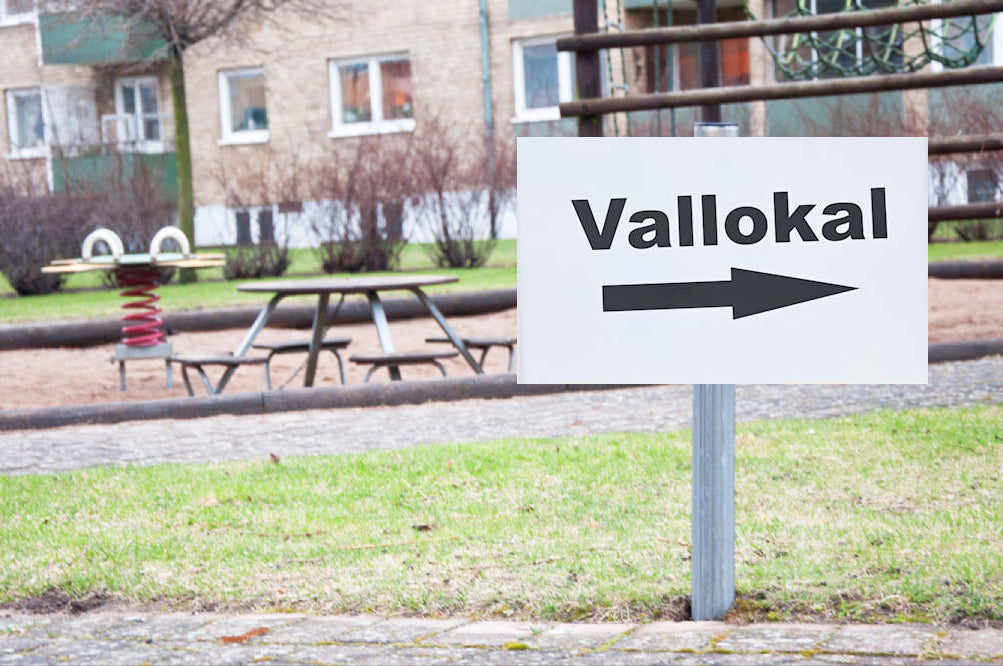 Stolpskyltar. "Vallokal" med pilar.