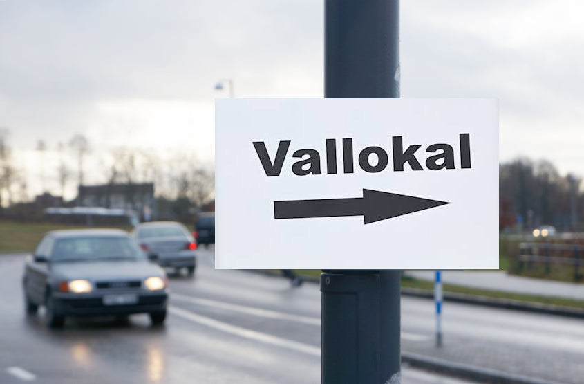 Stolpskyltar. "Vallokal" med pilar.