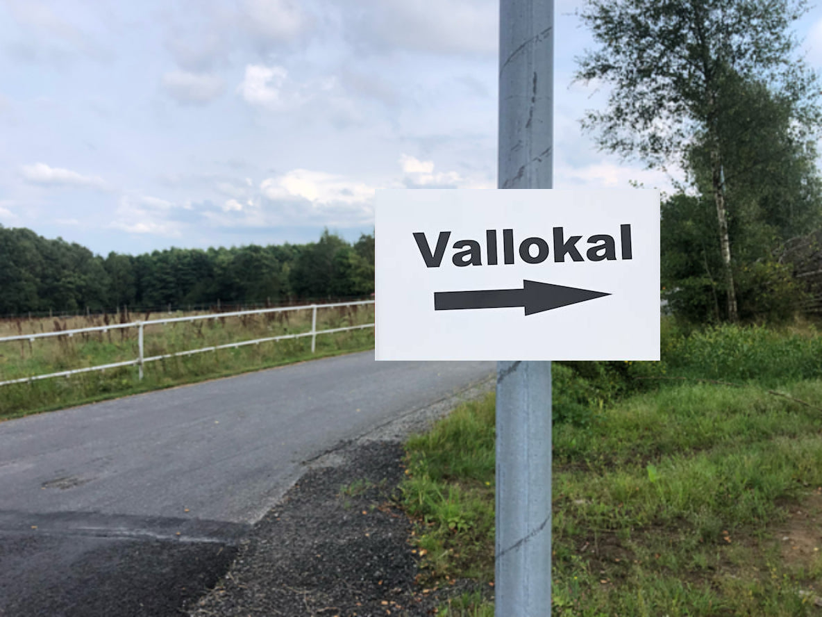 Stolpskyltar. "Vallokal" med pilar.